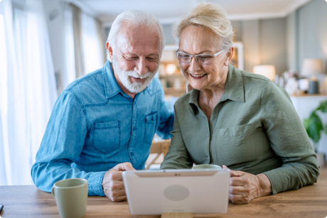 Pareja de personas mayores hablando por videollamada desde una tablet