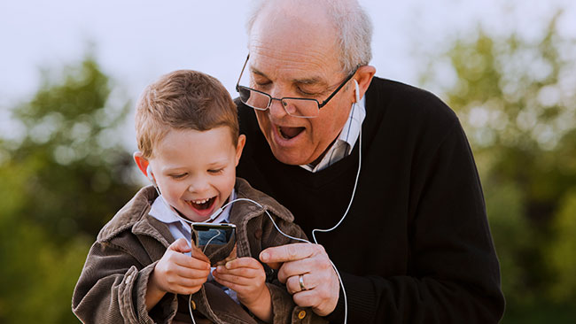 Abuelo y nieto usando el móvil