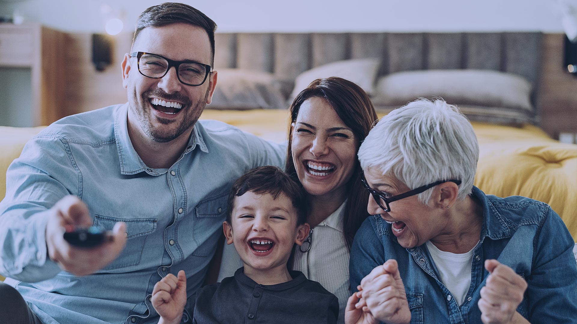 A smiling family in front of their living room television