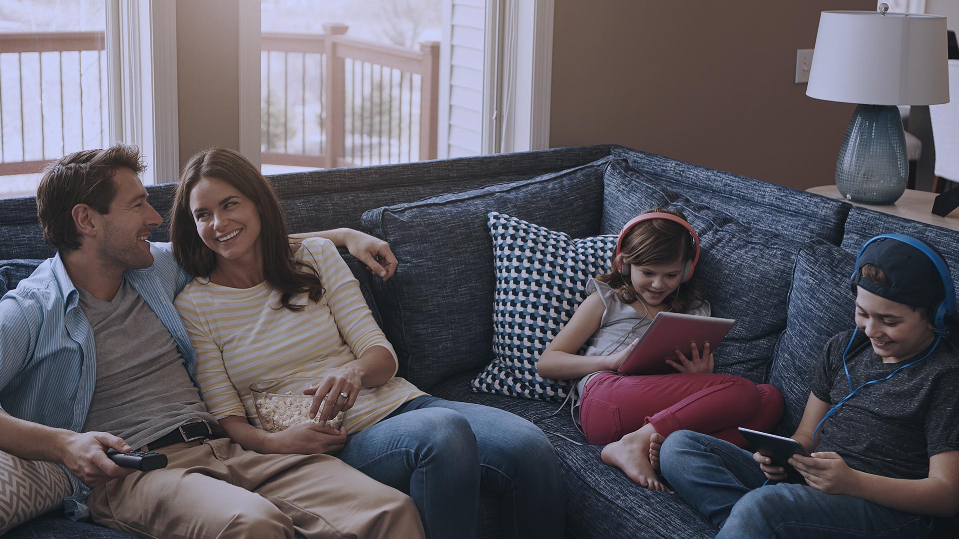 Familia con hijos sonriendo en el sofá